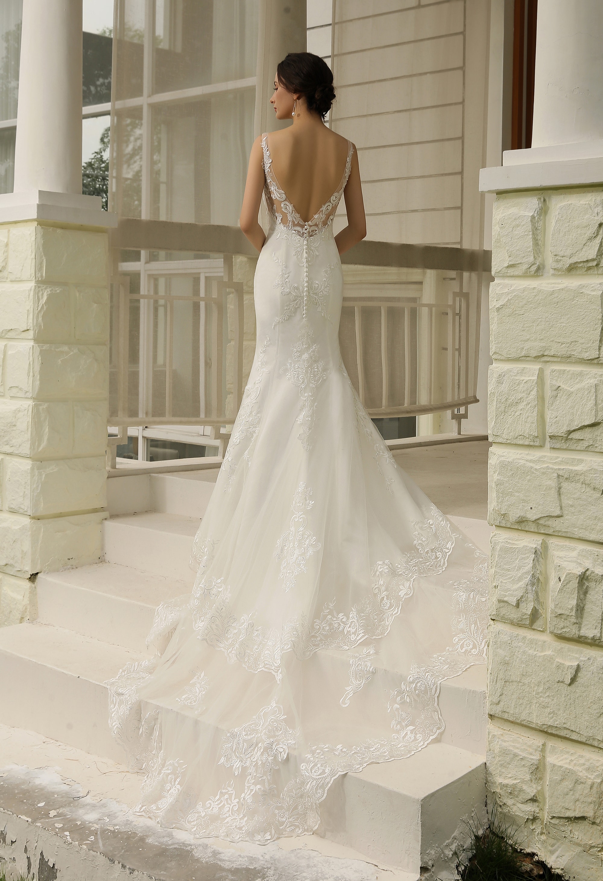 Bride in a dramatic long veil white wedding gown walking